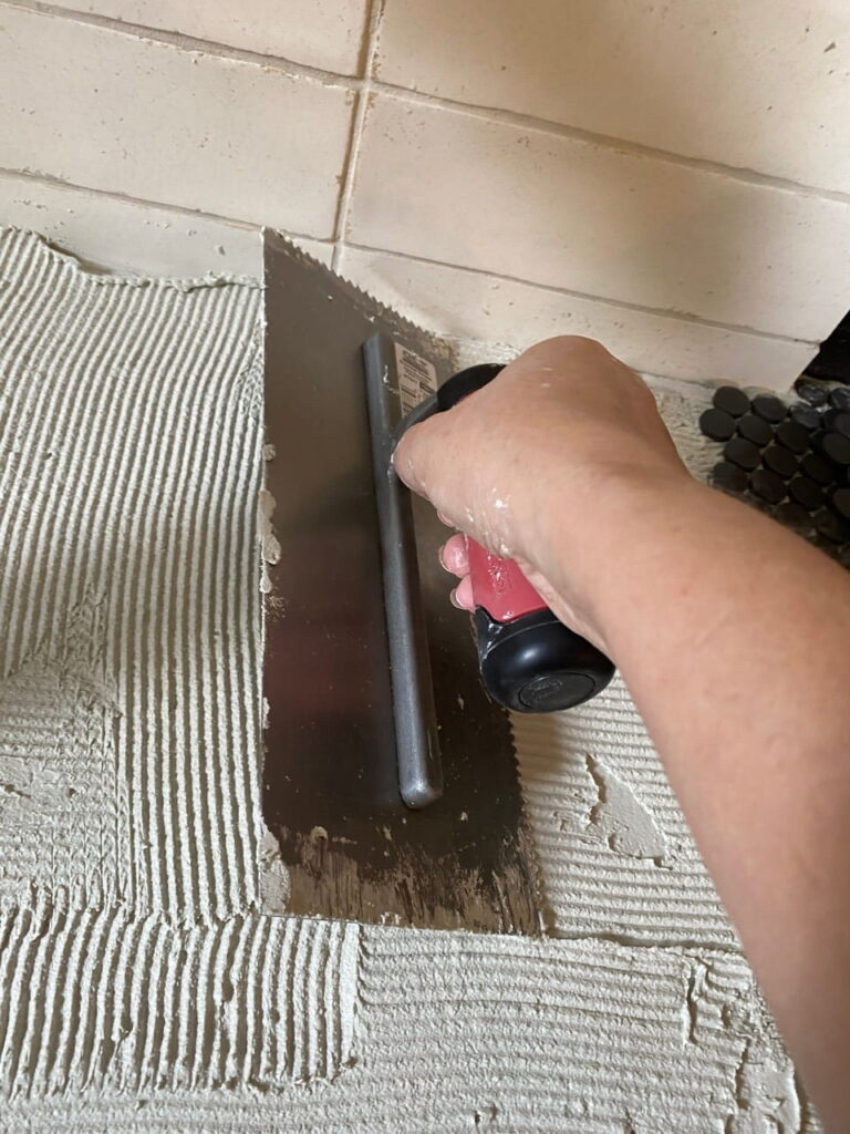 Using a trowel to comb thinset